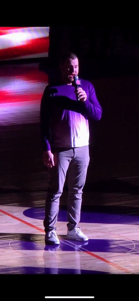 Royal Grubbs performing the national anthem on a basketball court